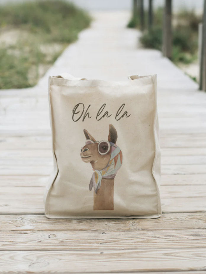 bolsa tote bag color natural con diseño camella maribella en ambiente de playa